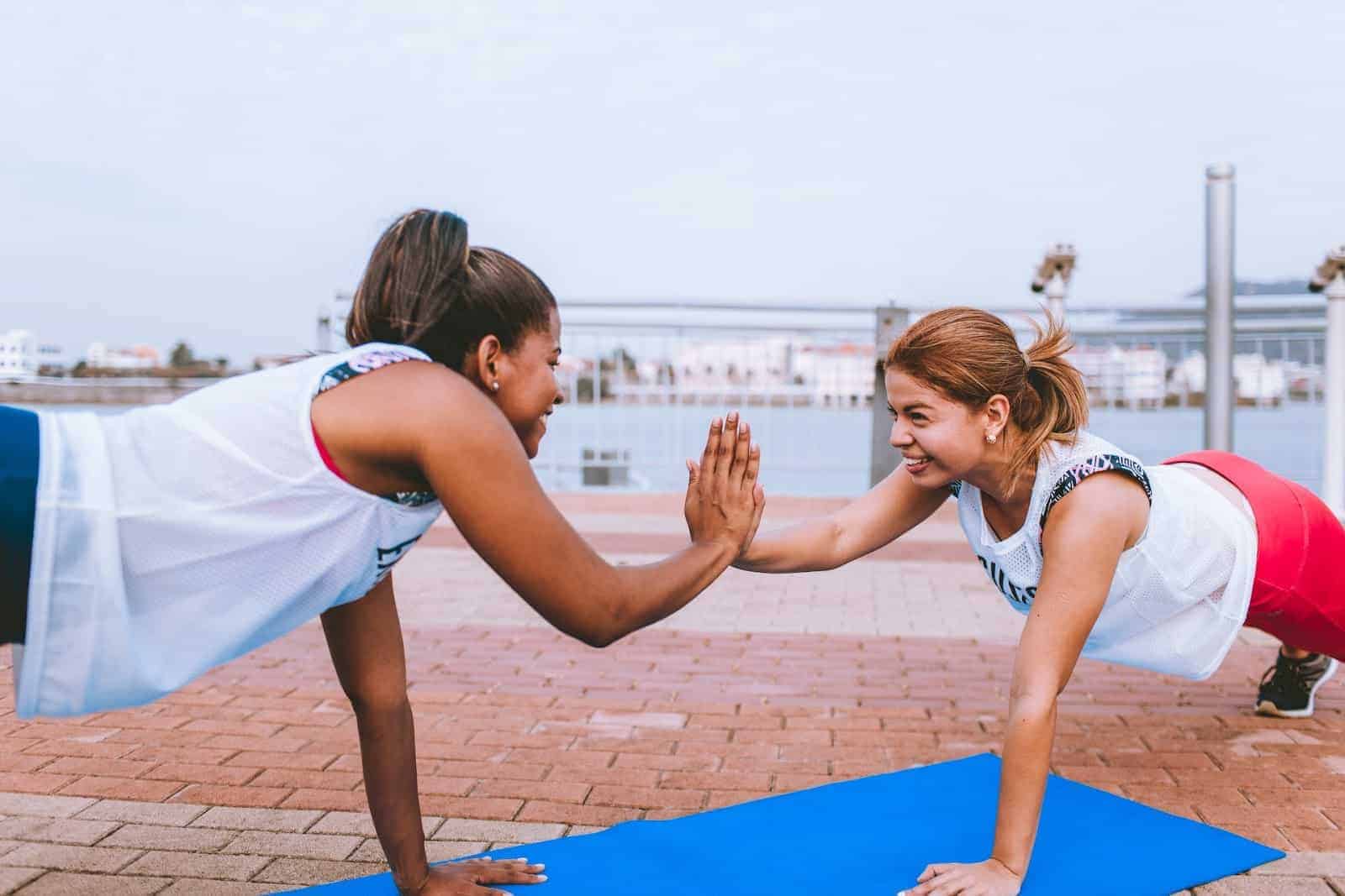 Two women in a plank position but also high-fiving each other in connection with a section about whether intermittent fasting is part of a healthy lifestyle.  