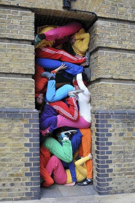 Kids in bright clothes stacked like blocks in between two buildings to illustrate staying ahead of swelling in Post-Op Recovery. 