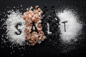 Piles of salt with the word salt written in salt to represent the importance of salt in your diet