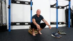 Image of Kelly squatting on a slant board to demonstrate how to use a slant board properly