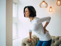 Woman holding her back in pain