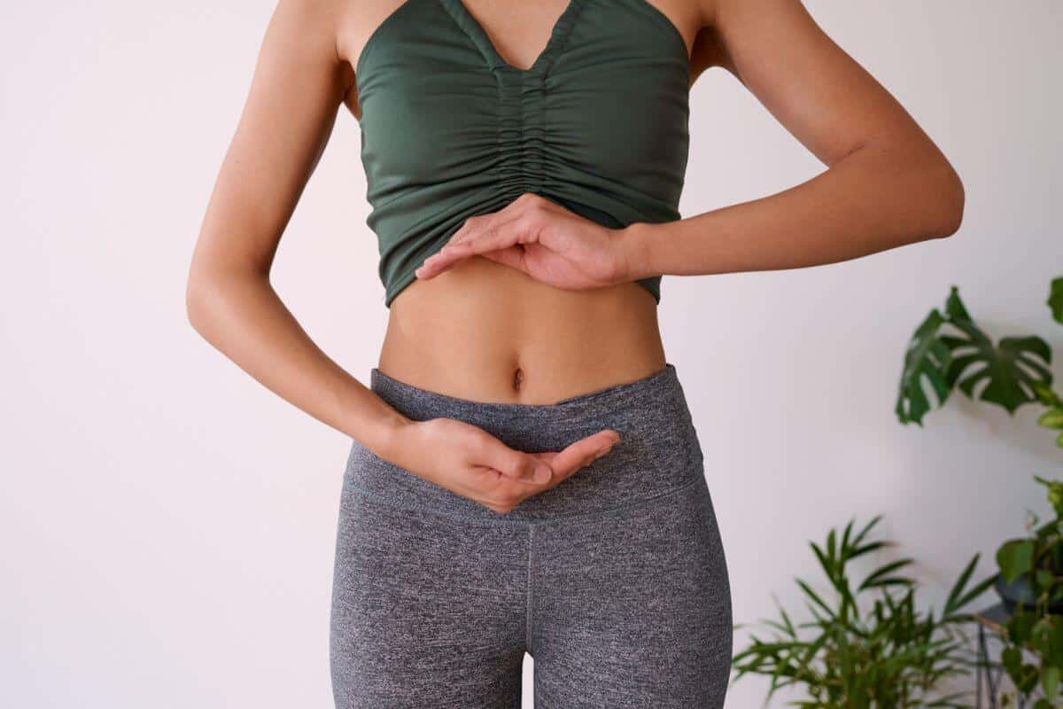 Woman in yoga pants cradling stomach